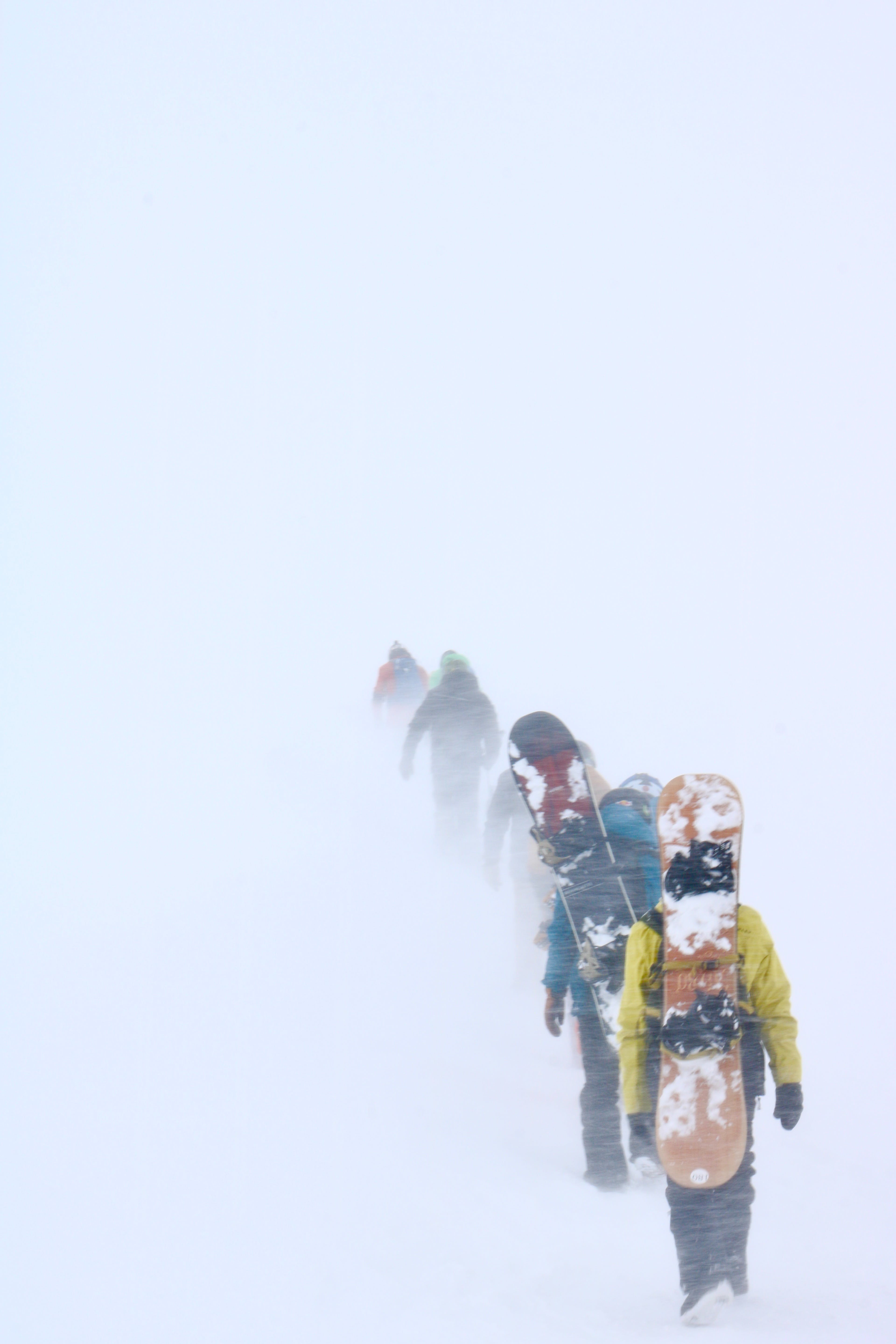 snowboarders walking in snow